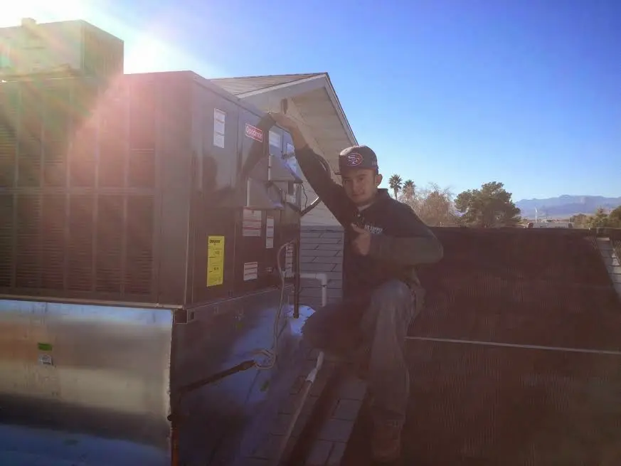 HVAC technician performing AC Tune-Up on a rooftop unit in Wakefield